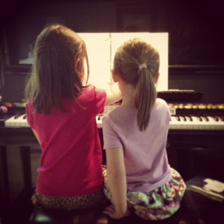 Bel and Lily practicing their piano at home
